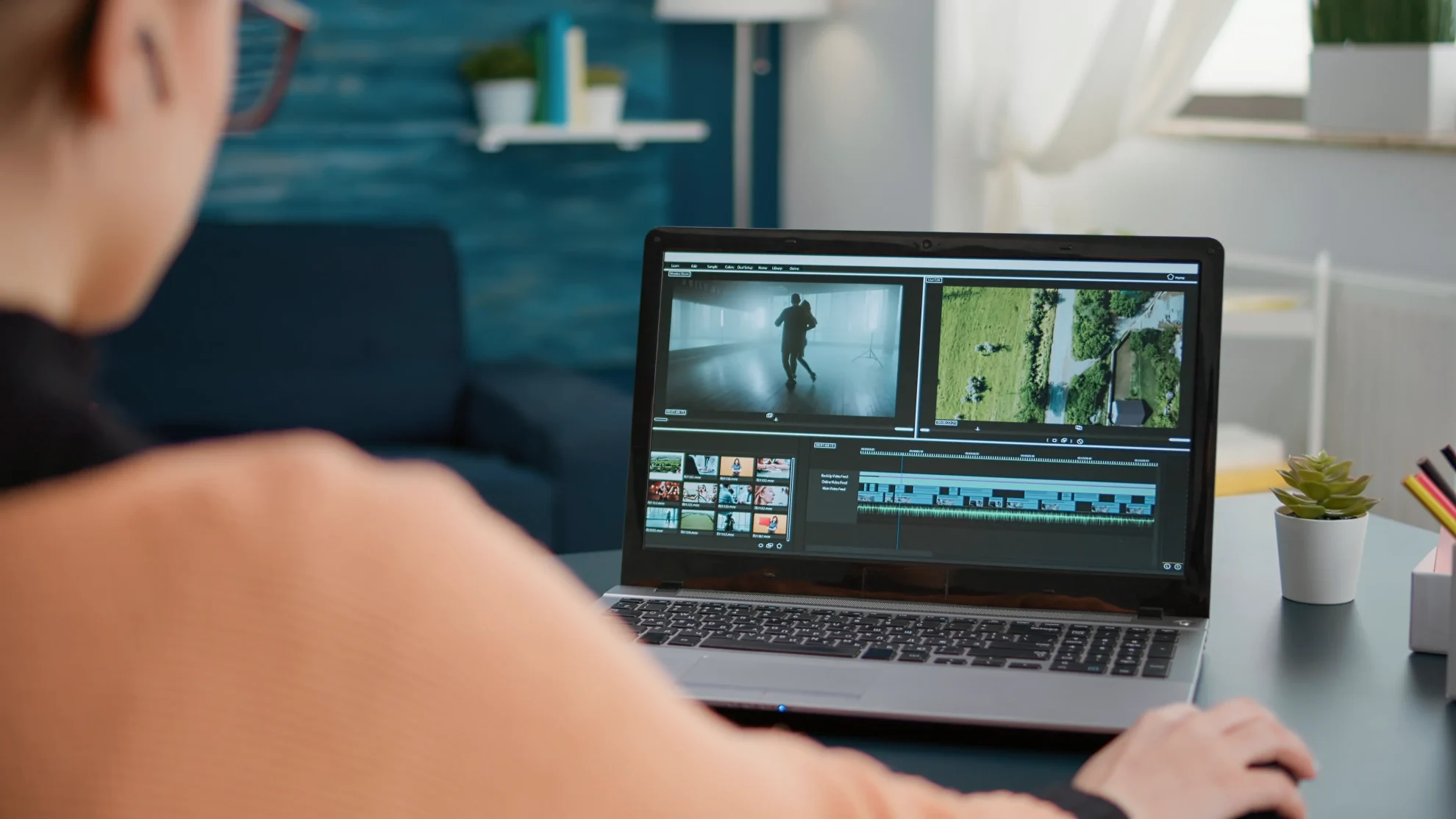 Pessoa sentada em frente a um computador com um editor de vídeo aberto.